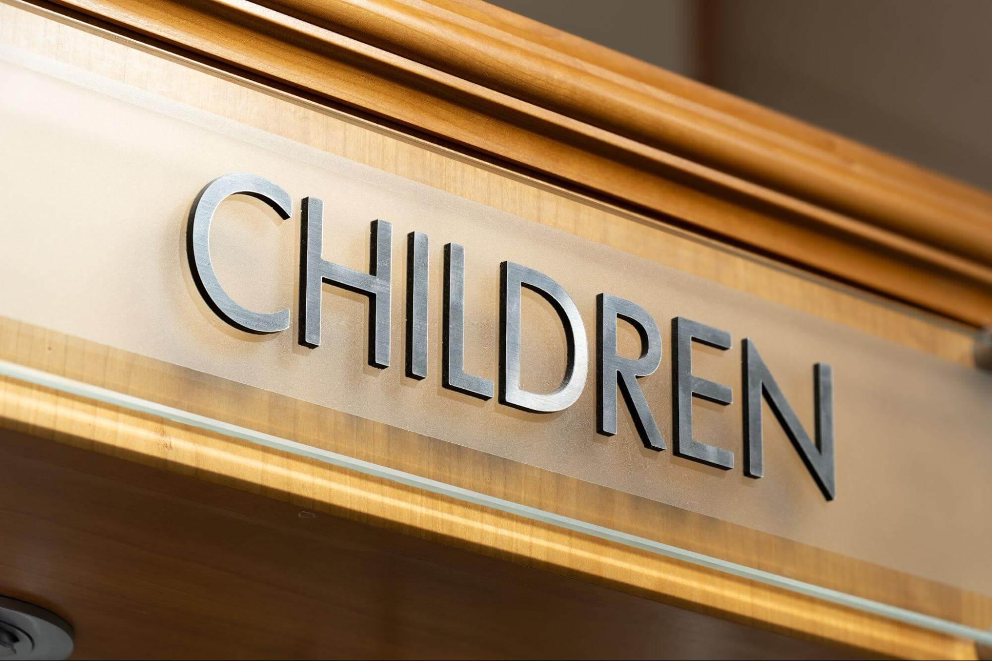 Close-up of a “CHILDREN” sign inside an eye care clinic.