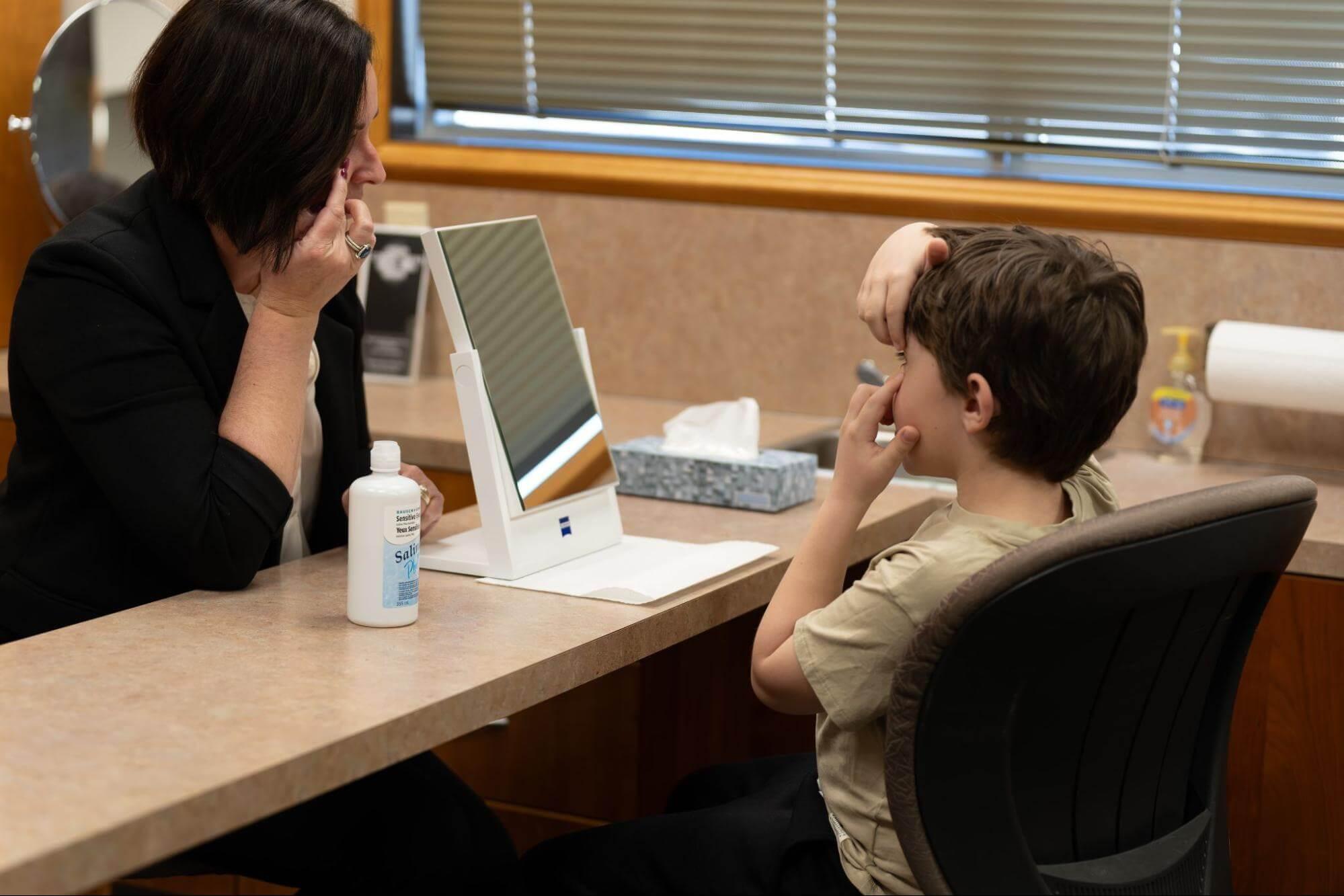 Eye care professional examining a child’s eyes during an eye exam.